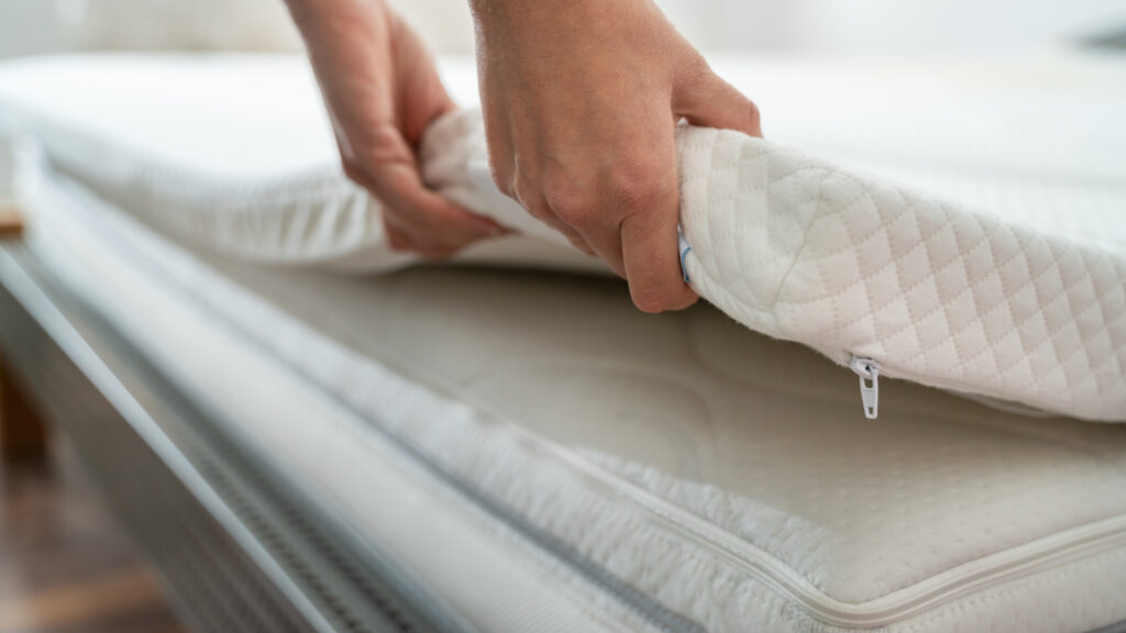 A person putting a foam topper on their rv mattress cut corner