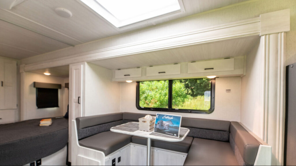 The dining and  bed area of an Estrada M-Class East to West RV