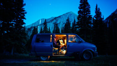 A person sitting in their van at night
