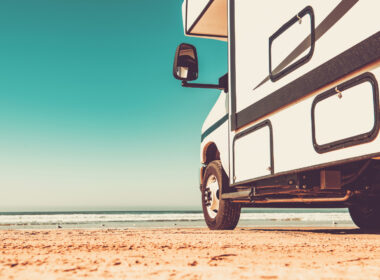 An RV parked in the sand at a beach