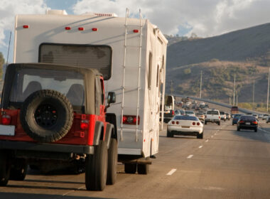 A jeep being flat towed by an RV