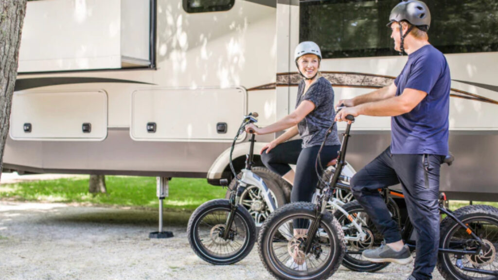 A couple on electric bikes outside of their fifth wheel using RV SnapPads