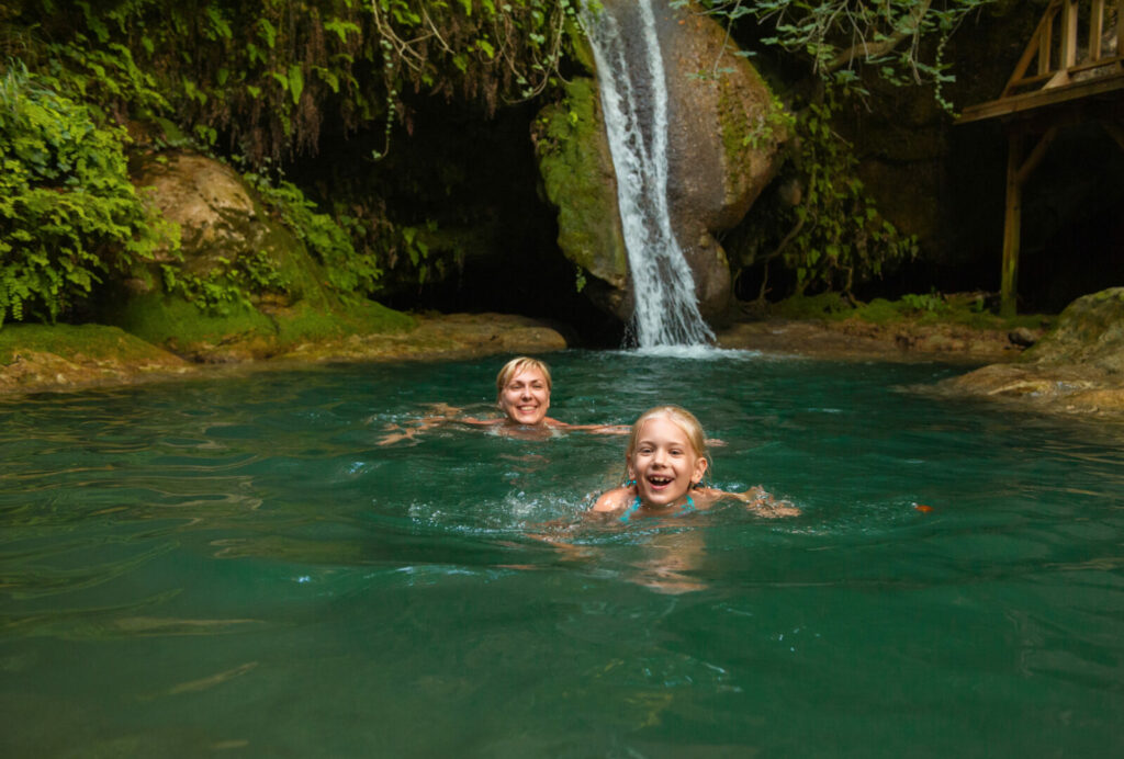Mom and daughter swimming in waterfall in New York