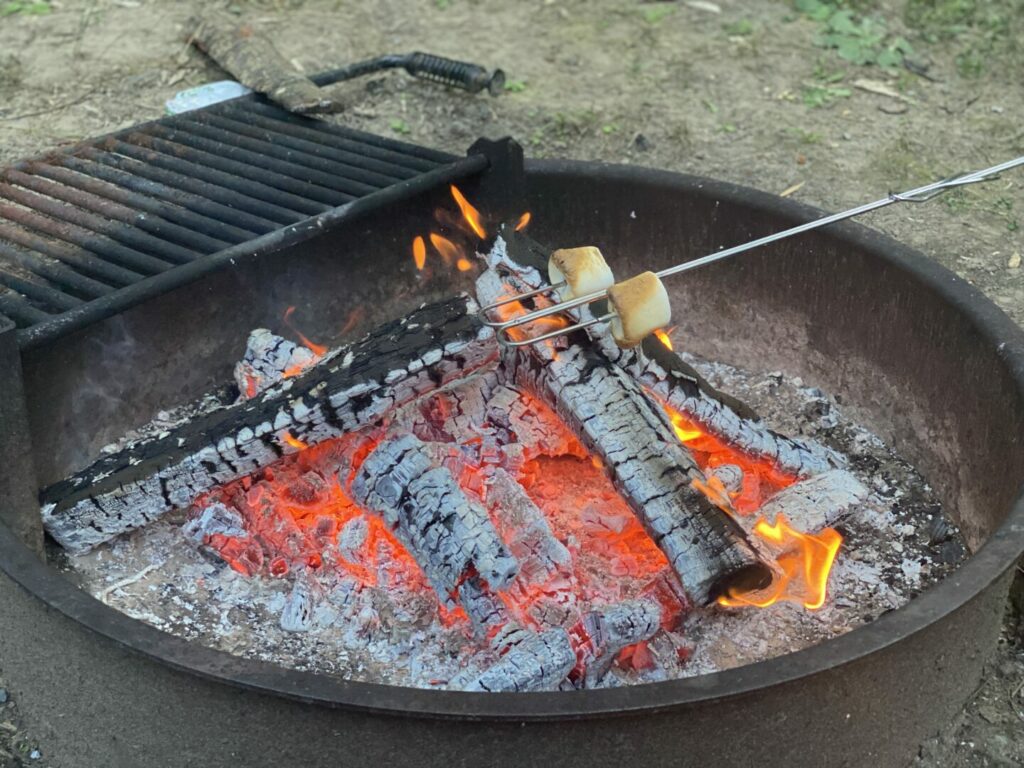 Marshmallows roasting over a campfire that was started with a campfire starter