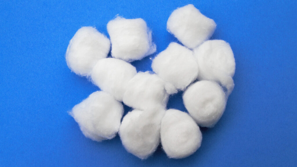 Cotton balls on a blue background that can be used as a campfire starter