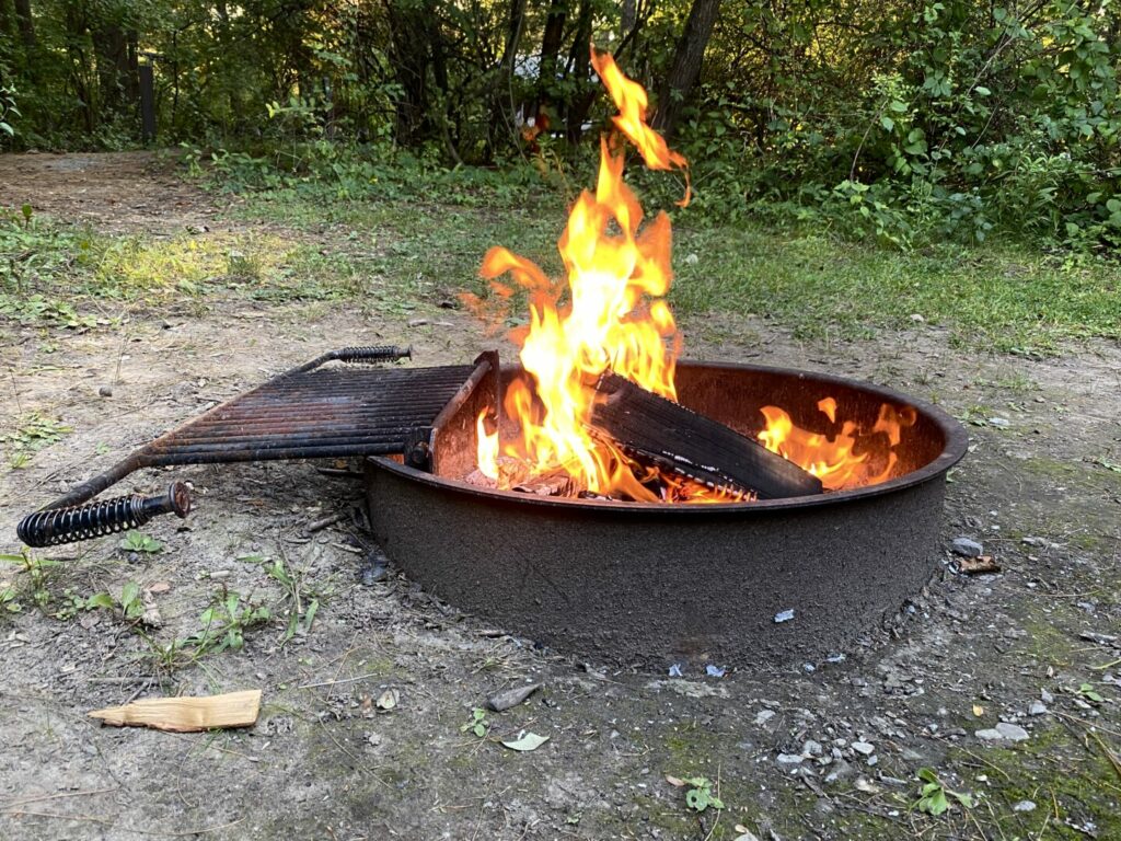 A roaring campfire in a metal fire pit that was started with a campfire starter 