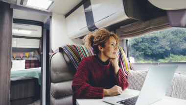 A woman working on her laptop in an RV to make money while on the road