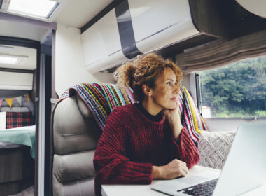 A woman working on her laptop in an RV to make money while on the road
