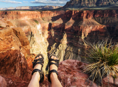 Close up of someone's feet sitting on the edge of the grand canyon