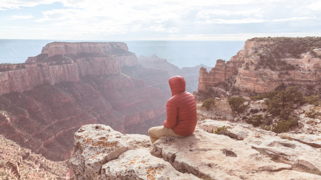 A person sitting on the edge of the Grand Canyon