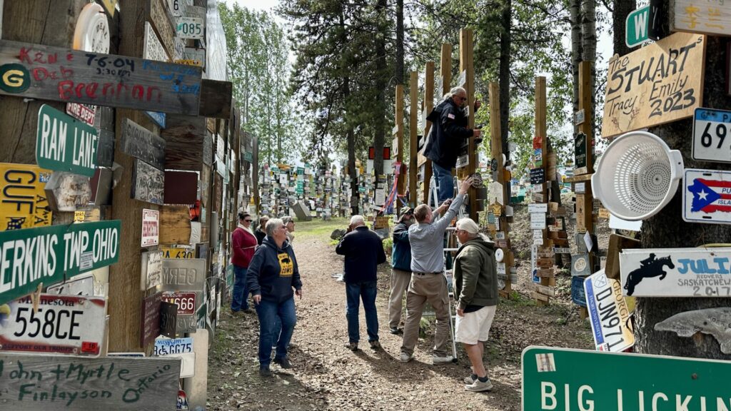 People walking around the sign post forest