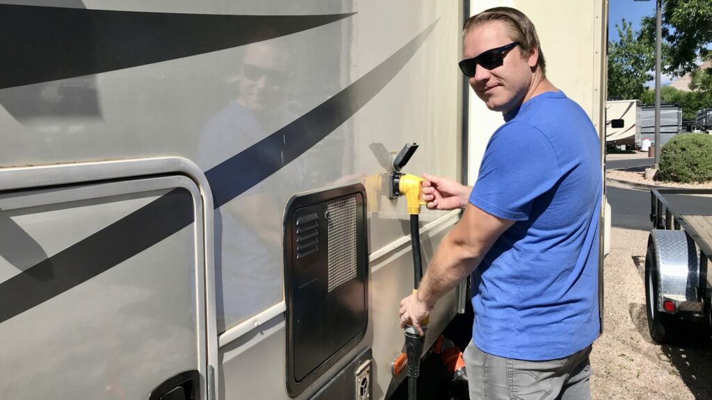 A man plugging in his RV electrical 