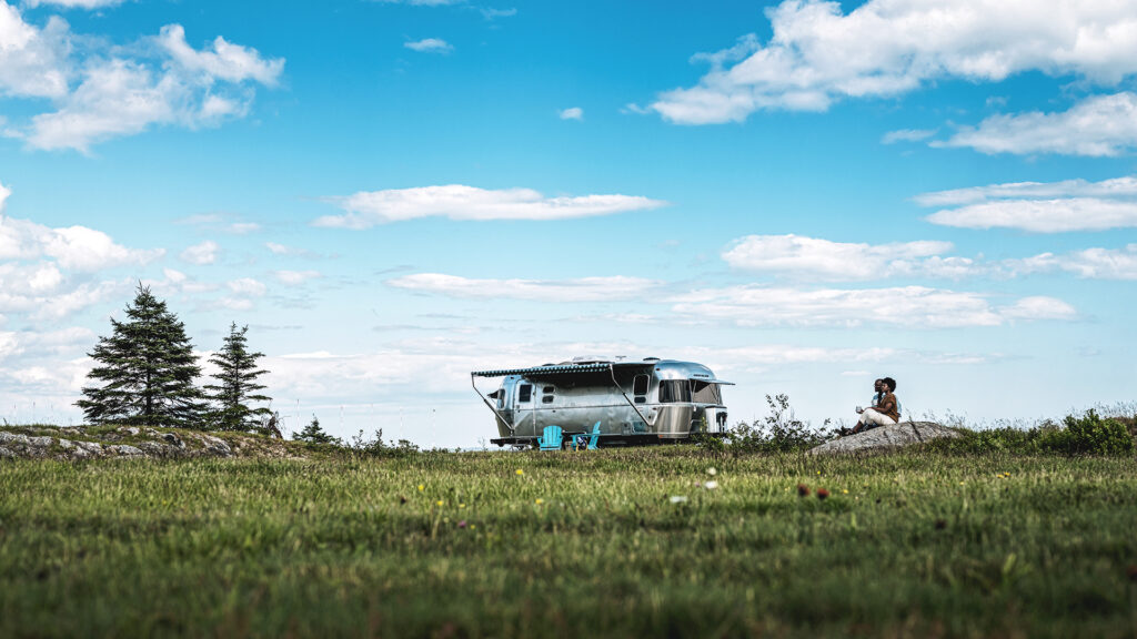 An airstream RV parked outside in the summer 