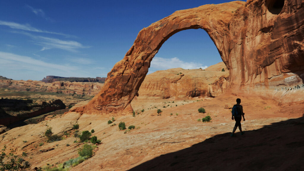 A person hiking at Corona Arch