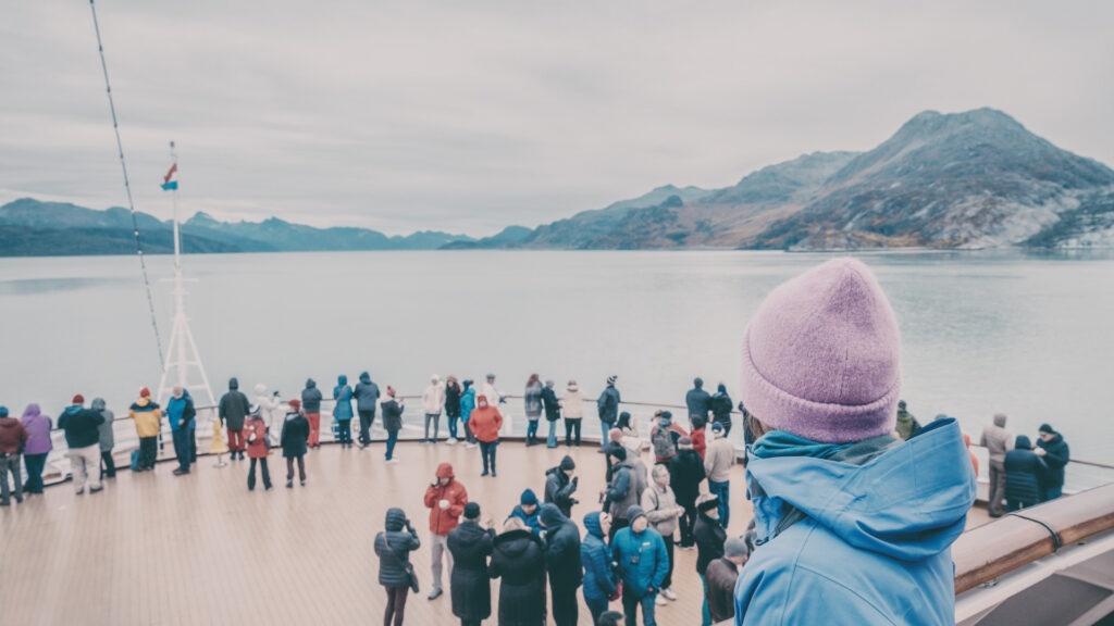 A group of tourists bundled in warm clothing on an Alaskan cruise