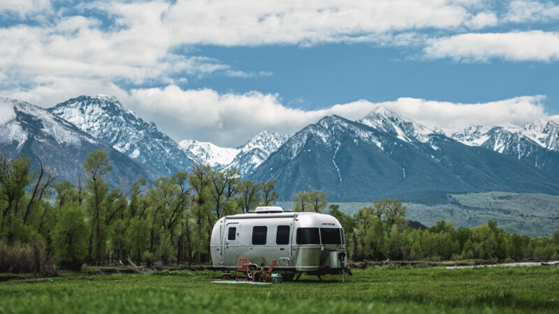 An Airstream parked outside by the mountains