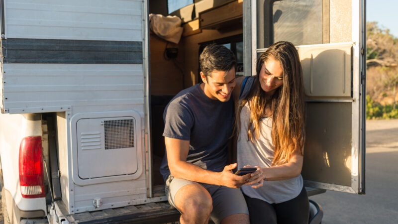 A couple using RVparky on their phone to find their next RV park