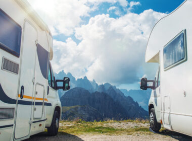 Two RVs parked by each other in front of the mountains