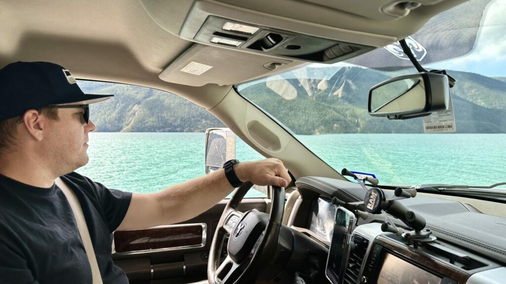 A man driving by Muncho Lake