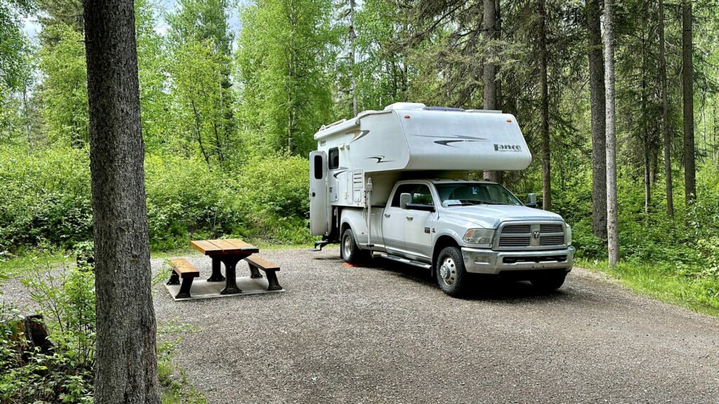 A truck camper parked in Liard River Hot Springs Provincial Park