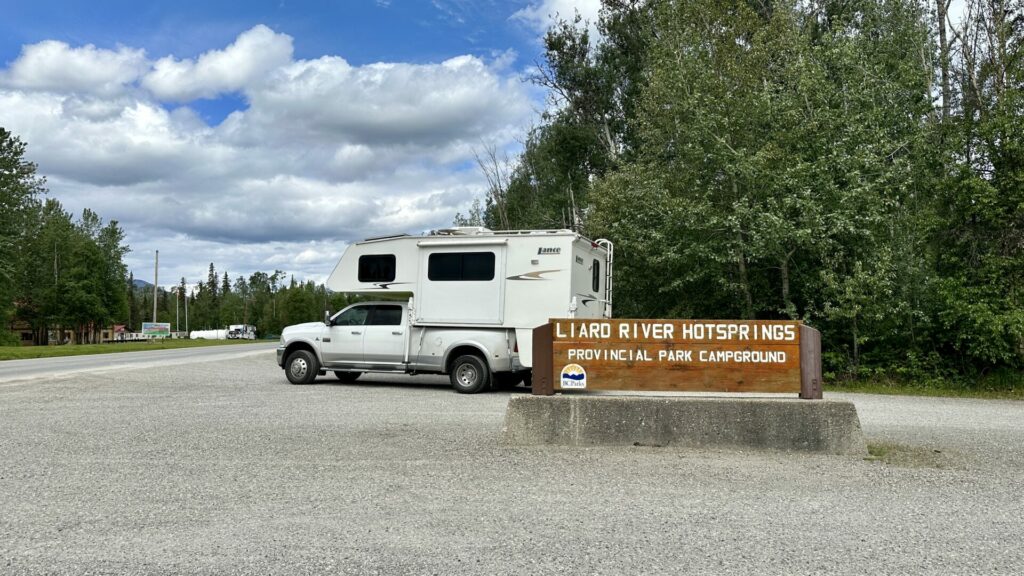 A truck camper parked outside of Liard Hot Springs