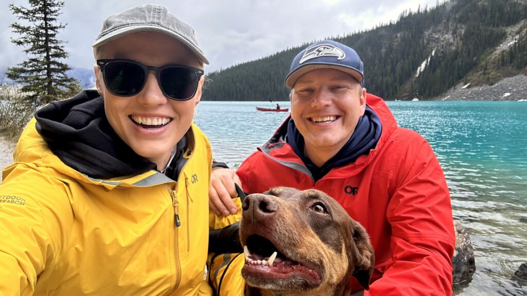 A couple with their dog taking a selfie on Lake Louise 