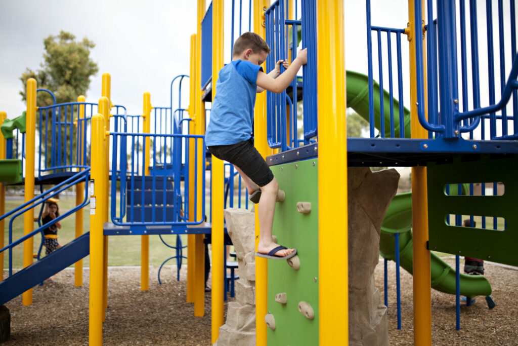 Boy climbing on playground at Cedar Beach Park