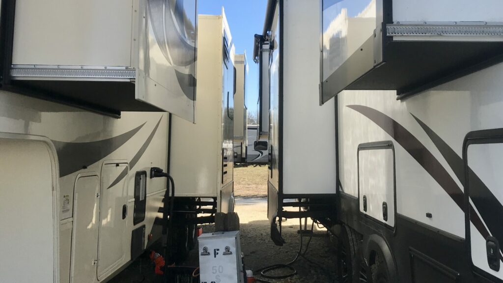 Two RVs parked extremely close to each other at the thousand trails lake conroe RV park. 