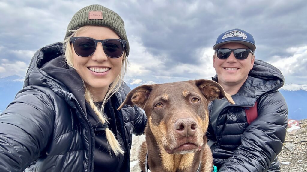 A couple smiling with their dog at the Jasper Skytram