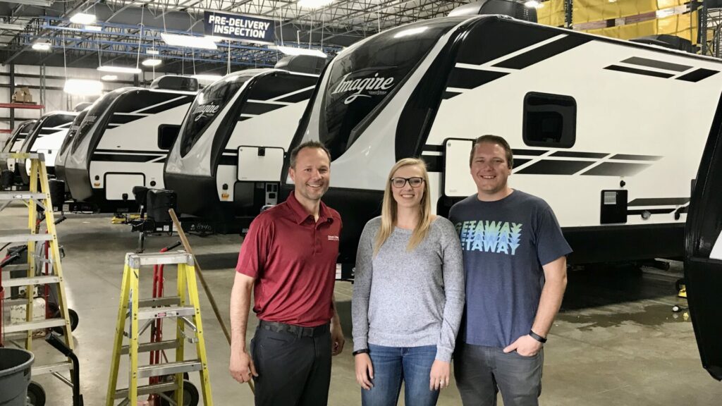 A group smiling inside an RV manufacturer factory at Elkhart, Indiana 