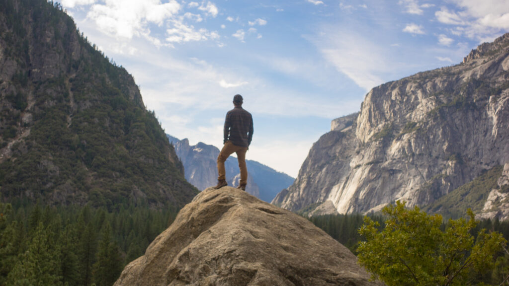 A man standing on a cliff in Yosemite National Park
