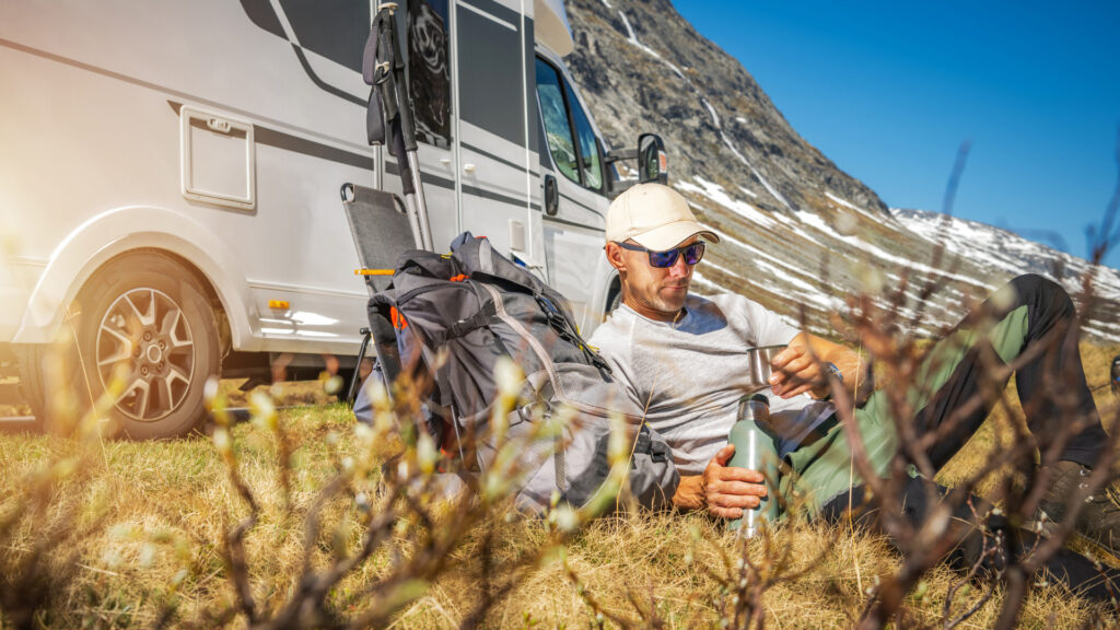 A man sitting outside of his RV while boondocking