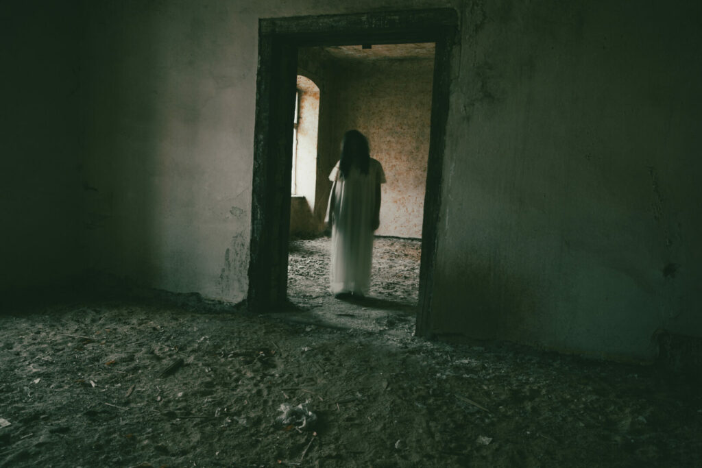 Woman ghost in hospital gown standing in doorway of Norwich State Hospital