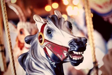 Close up of the neighing head of a carousel horse at an amusement park.