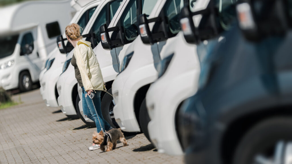 A woman walking around an RV dealership with her dog