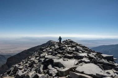 A hiker at the summit of Wheeler Peak in New Mexico on a clear day.