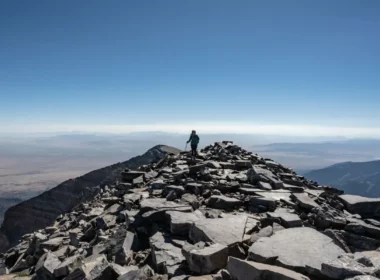 A hiker at the summit of Wheeler Peak in New Mexico on a clear day.