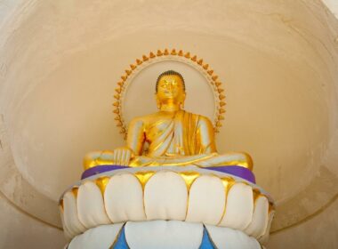 Close up of a golden Buddha statue on a pedestal at the Peace Pagoda in Massachusetts.