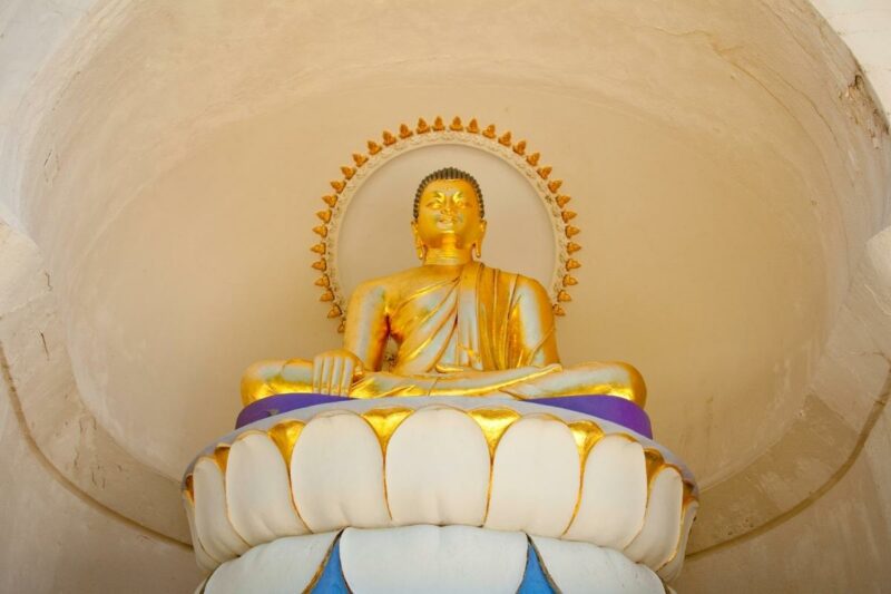 Close up of a golden Buddha statue on a pedestal at the Peace Pagoda in Massachusetts.