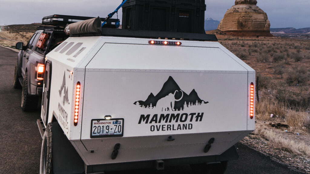 The back of a Mammoth Overland trailer attached to a truck driving in a national park