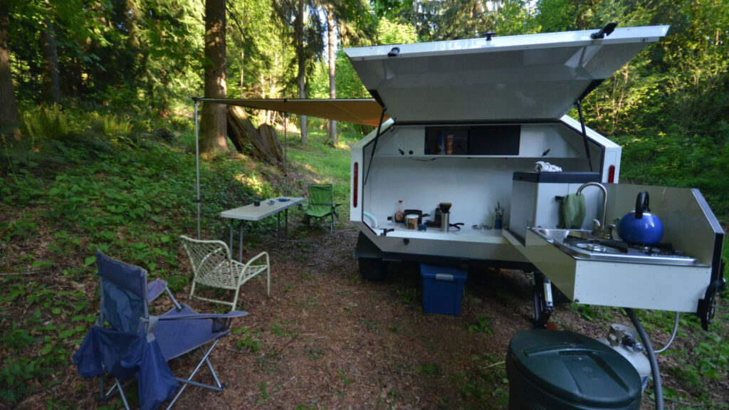A Mammoth Overland trailer outdoor kitchen set up at a campsite