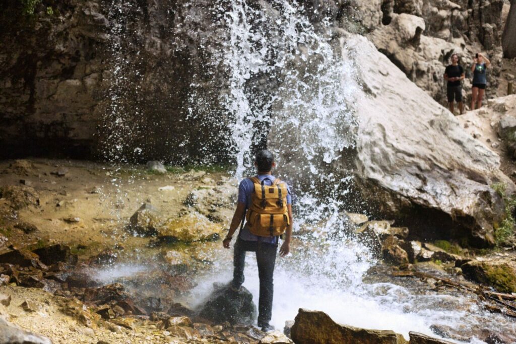 Man hiking and looking at Colorado waterfall