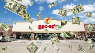 A buc-ee's location with dollar bills flying around it