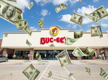 A buc-ee's location with dollar bills flying around it