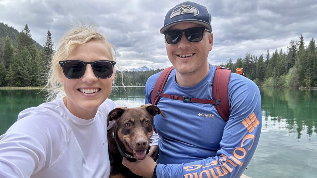 A couple smiling with their dog in Jasper National Park while hiking the Valley of the Five Lakes.
