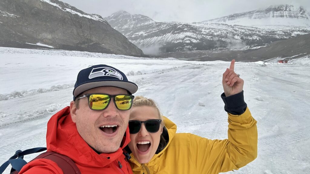 A couple taking a selfie at Athabasca Glacier, one of the top 10 stops off the Icefields Parkway