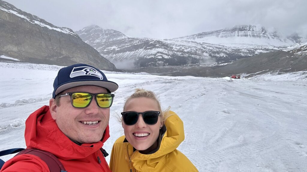 A couple smiling while taking a selfie at the Columbia Icefield Glacier Adventure