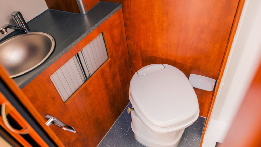 View of an RV toilet in a bathroom.