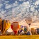 A row of hot air balloons lined up for a morning flight at the Albuquerque Balloon Fiesta.