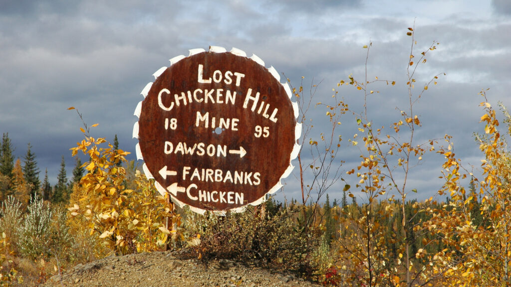 A sign off the Taylor Highway pointing to the towns of Dawson, Fairbanks and Chicken.